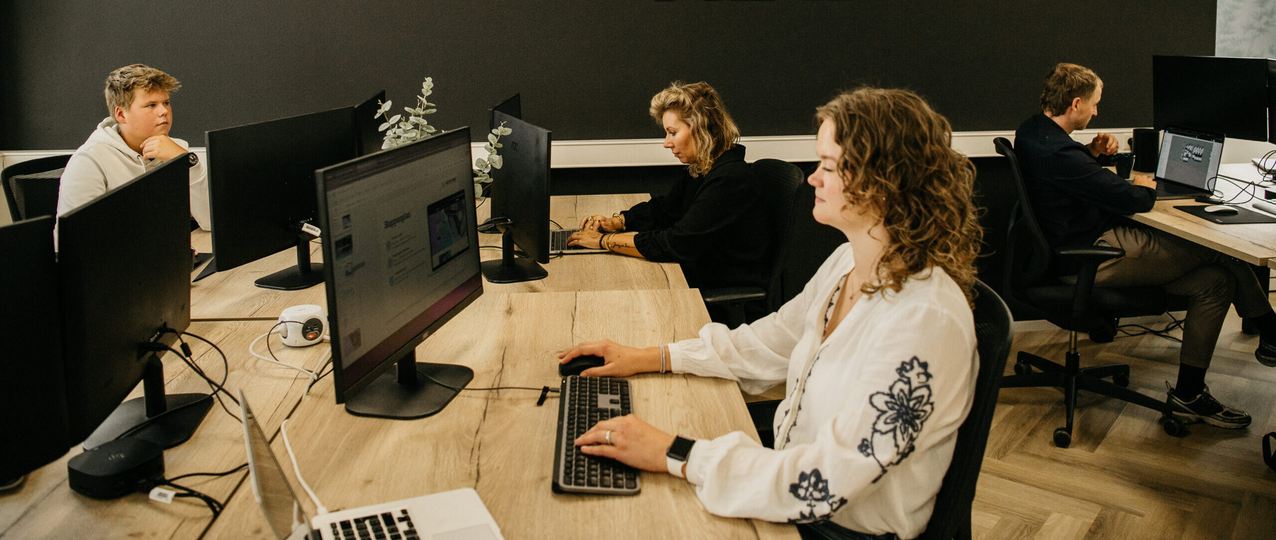 Het personeel van rijders webdesign aan het werk achter de computers.